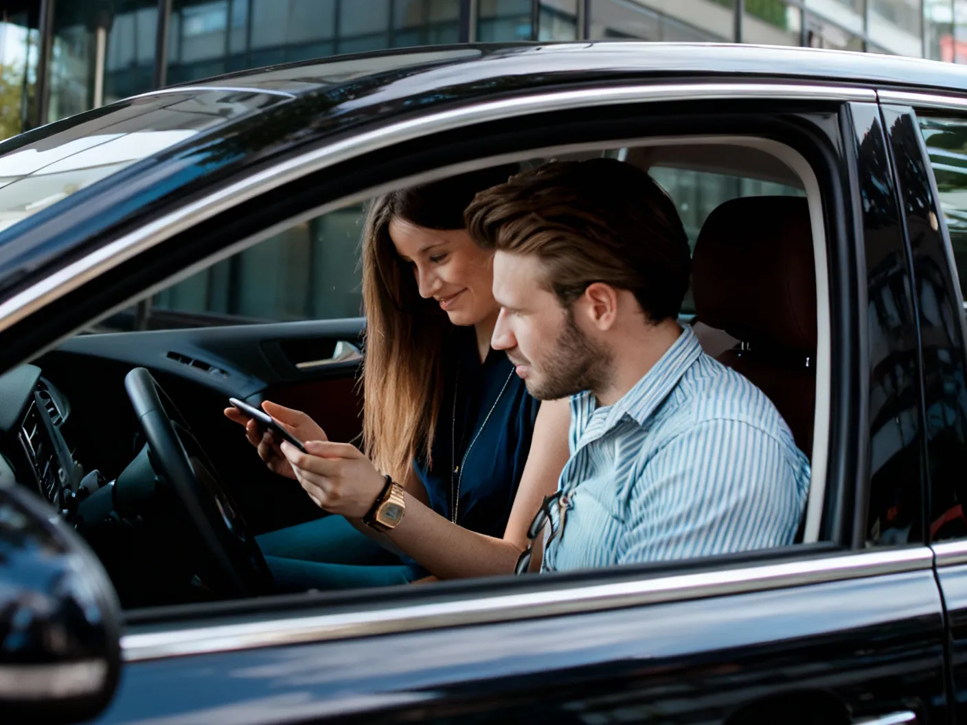 Conductor y pasajera consultando la app de coche compartido
